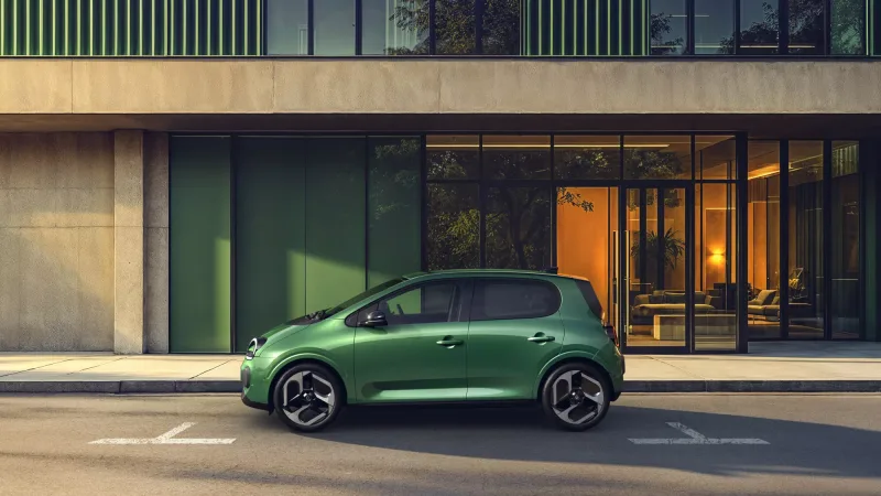 Renault Twingo E-Tech electric verte vue de profil devant un bâtiment moderne